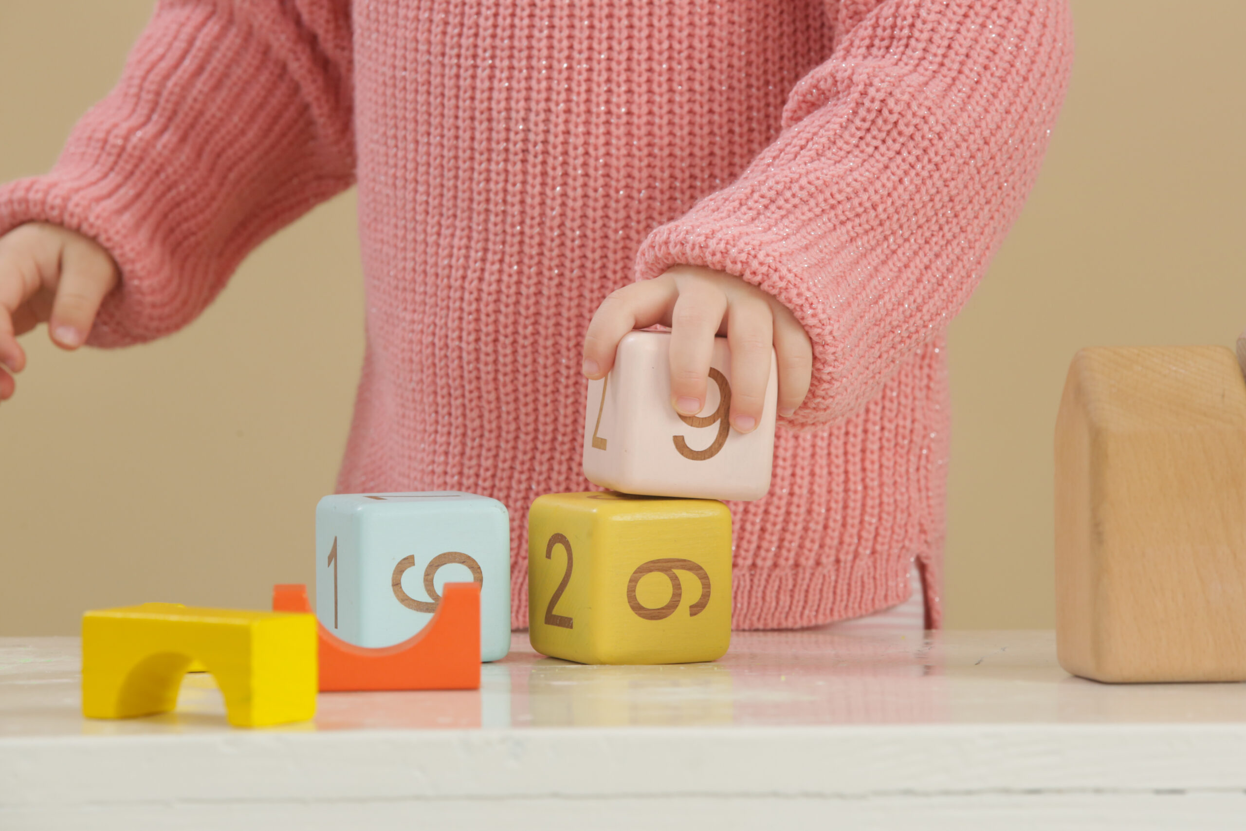 A young child playing with blocks in a daycare or school environment.